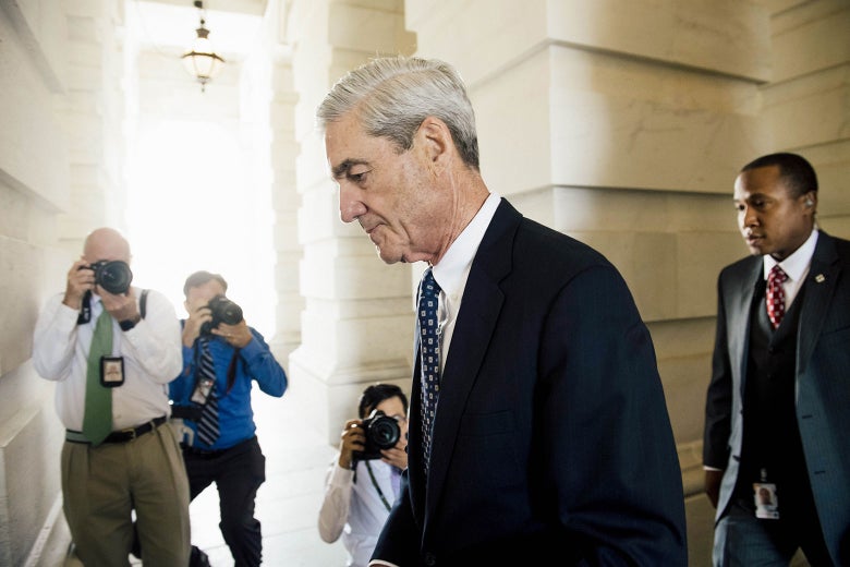 Robert Mueller walks out of a building.